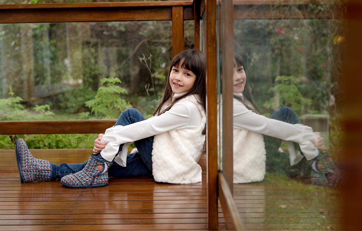 foto de familia em caxias do sul fotografa morgana perini menina sentada em varanda de madeira