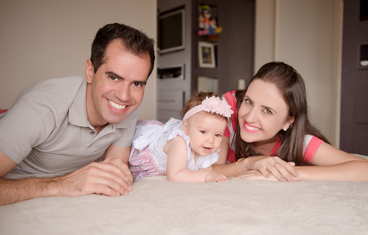 foto de bebe em caxias do sul fotografa morgana perini bebe deitada na cama com os pais