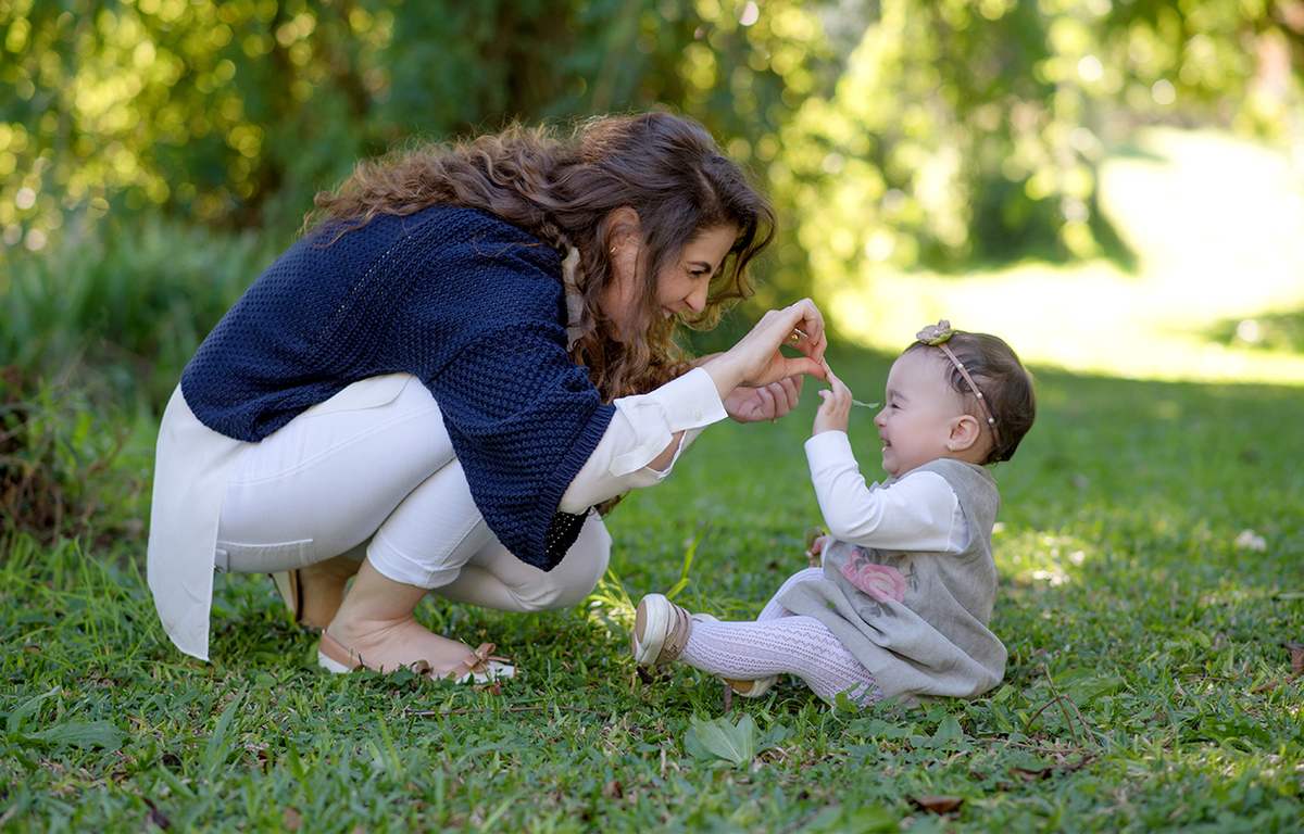 foto de bebe em caxias do sul fotografa morgana perini mae brincando com bebe sentada na grama