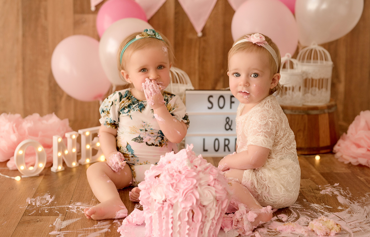 foto de gemeas em caxias do sul fotografa morgana perini bebe comendo bolo e ollhando para camera
