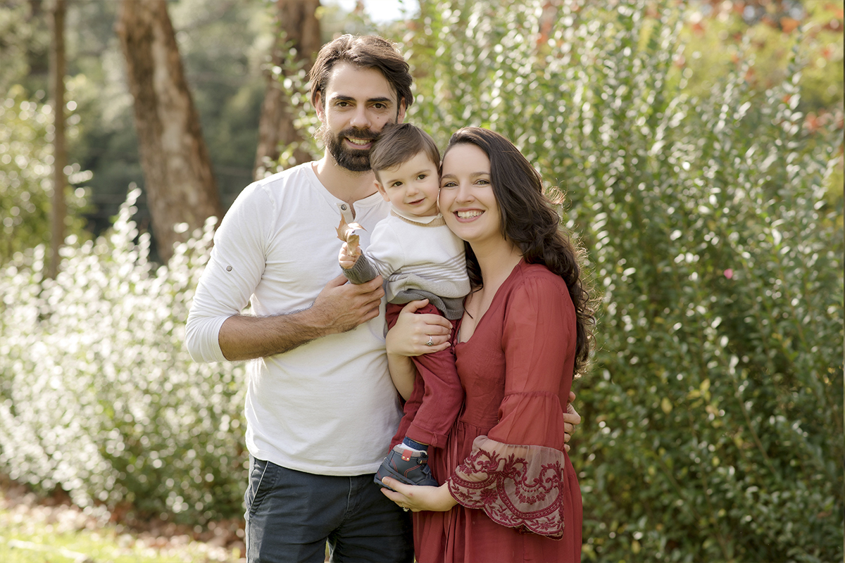 foto de criança em caxias do sul fotografa morgana perini pais com filho os braços flores ao fundo
