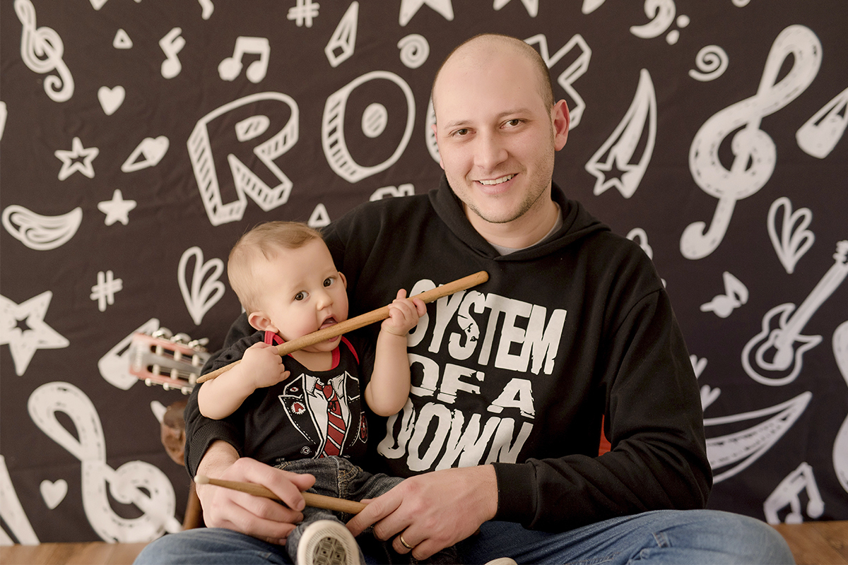 foto de bebe em caxias do sul fotografa morgana perini bebe com baqueta no colo do pai