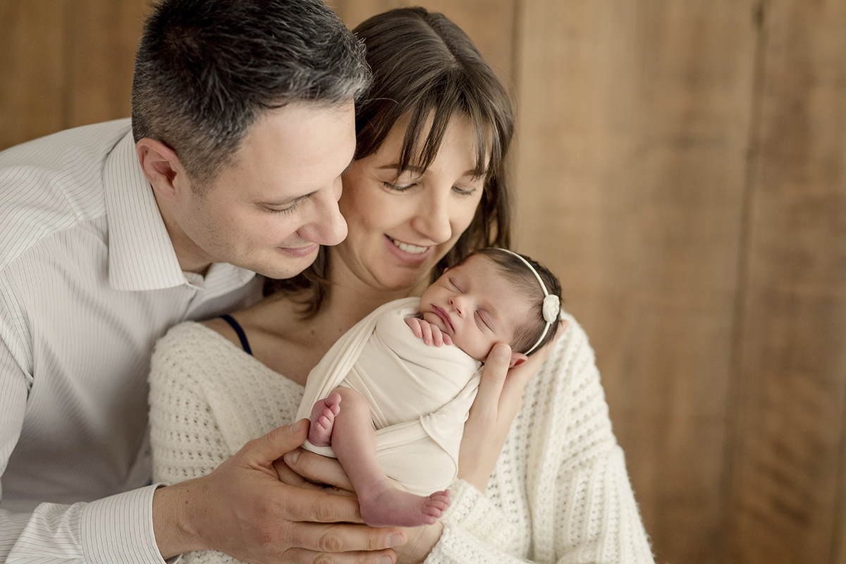 foto de bebe em caxias do sul fotografa morgana perini pais segurando bebe recem nascido