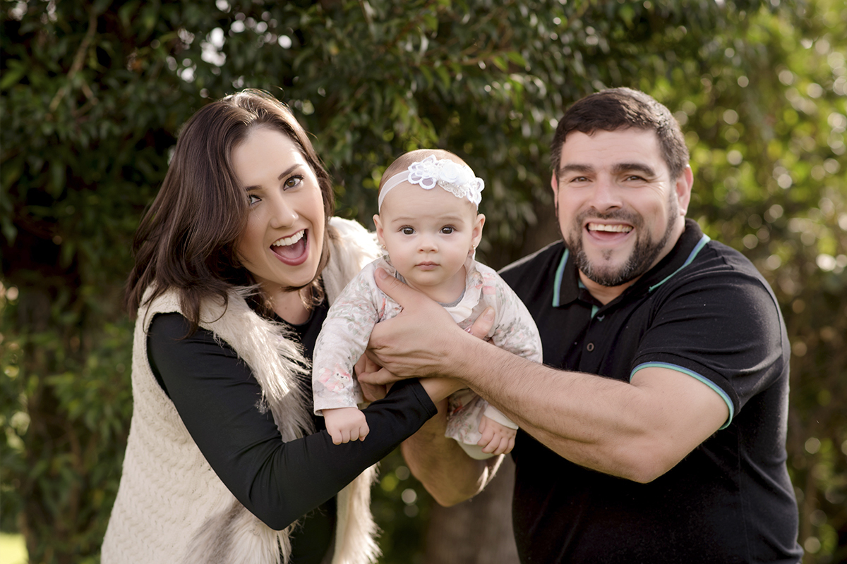 foto de bebe em caxias do sul fotografa morgana perini bebe brincando com os pais em meio a arvores