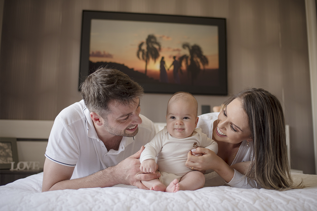 foto de bebe em caxias do sul fotografa morgana perini pais deitado na cama com bebe