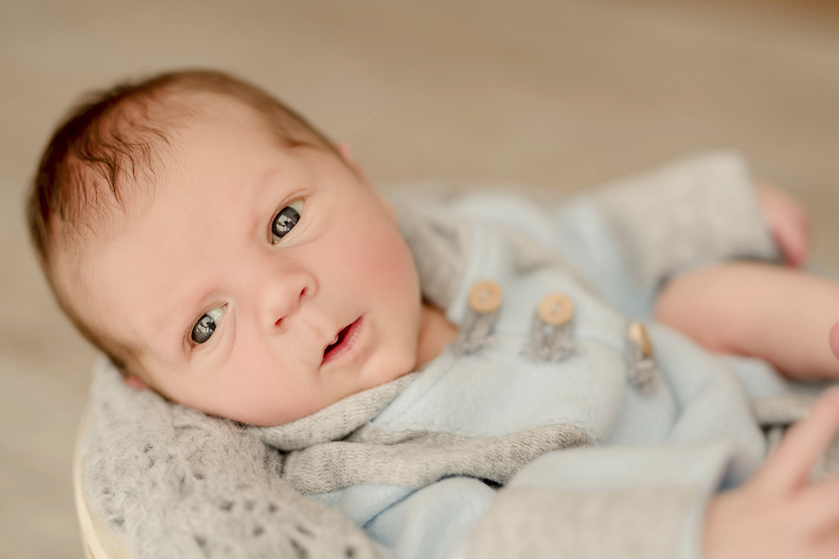 foto de bebe em caxias do sul fotografa morgana perini bebe deitado com olhos abertos e roupa azul