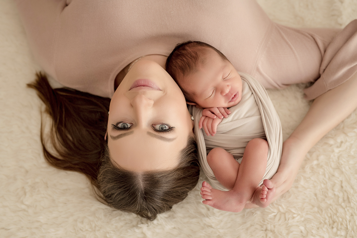 foto de bebe em caxias do sul fotografa morgana perini mae deitada com bebe olhos azuis