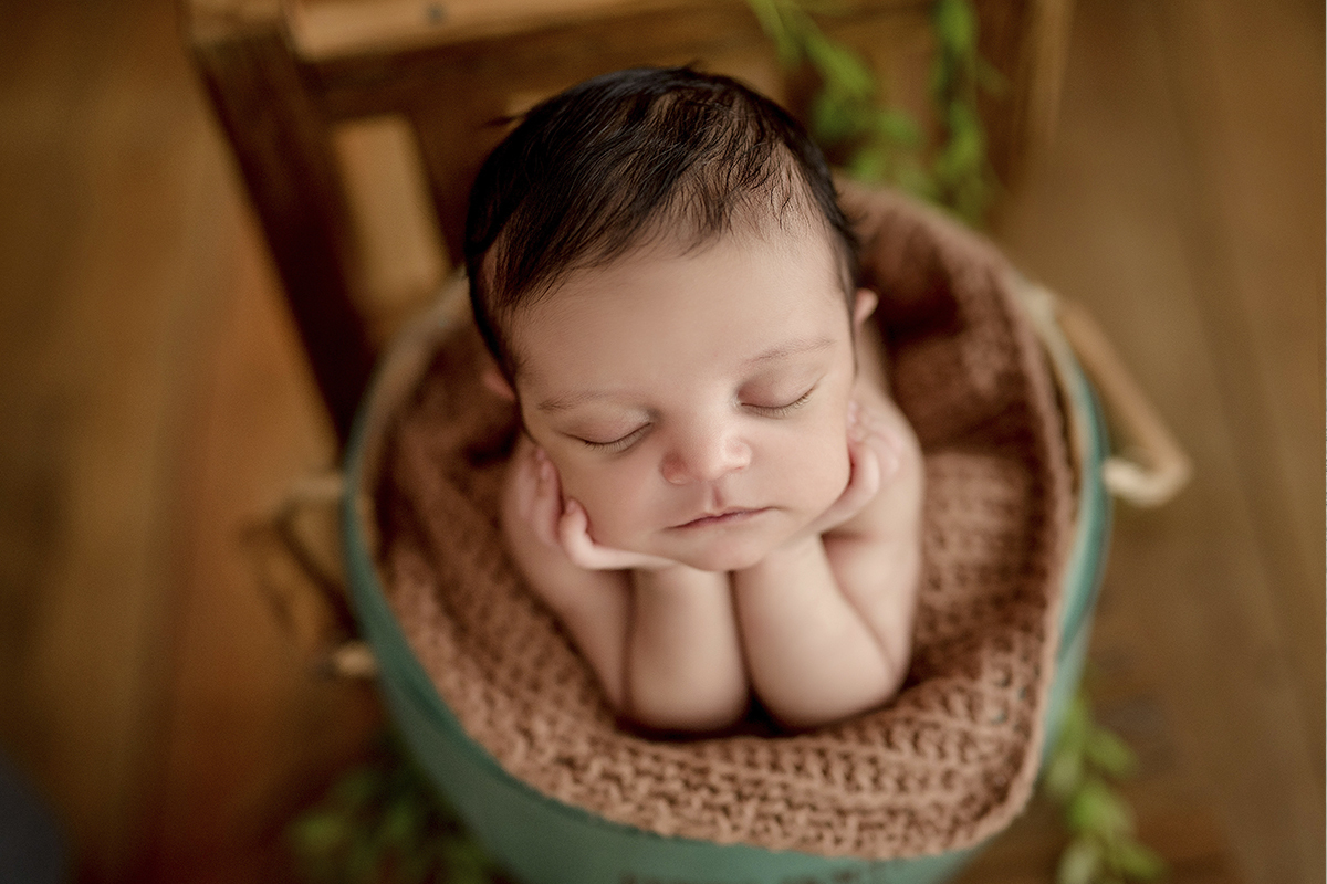 foto de bebe em caxias do sul fotografa morgana perini bebe segurando o rostindo com manta marrom