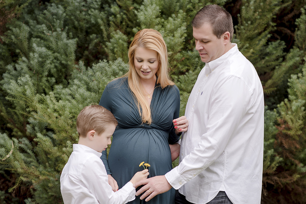 foto de gestante em caxias do sul fotografa morgana perini criança com flor na mao em frente a mae