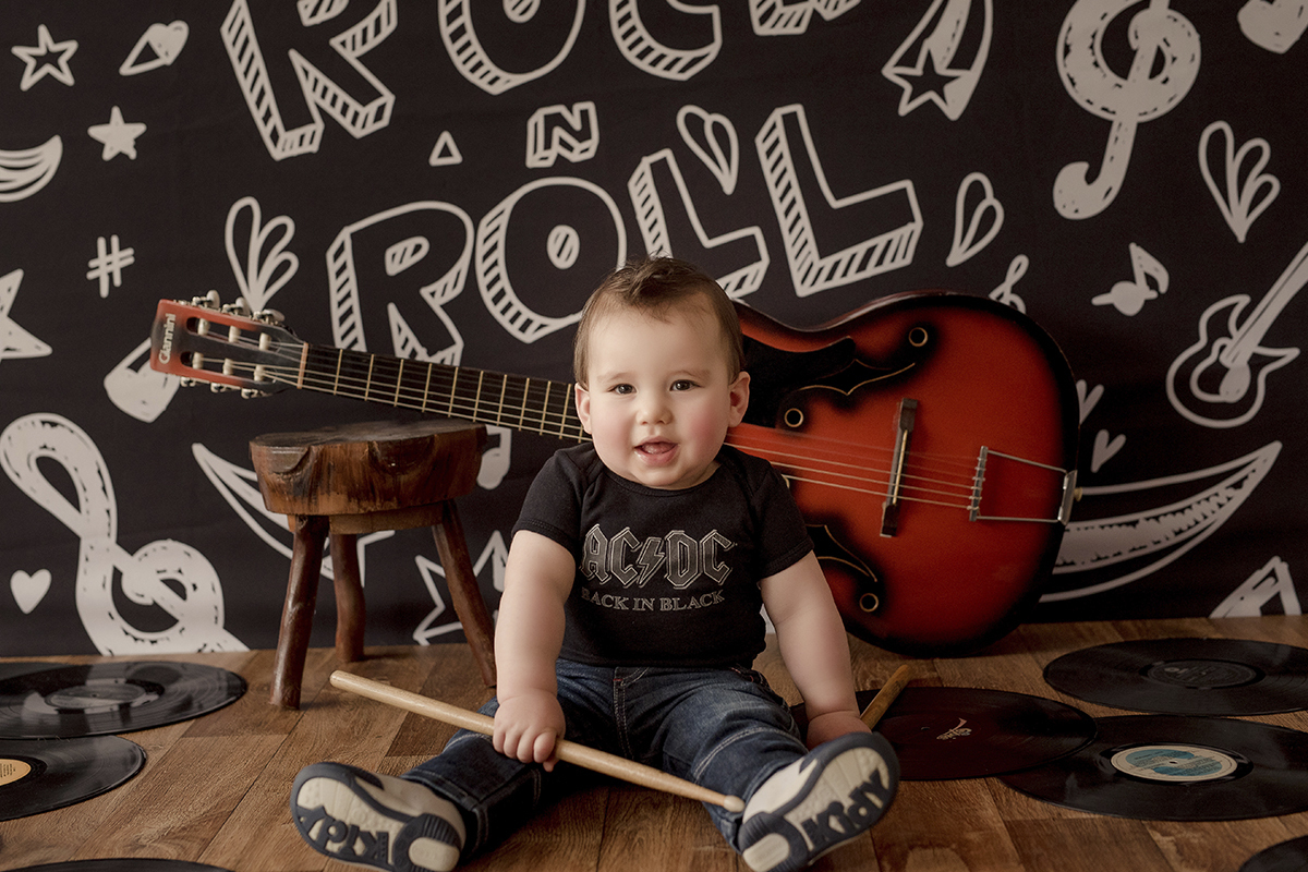 foto de criança em caxias do sul fotografa morgana perini bebe com baqueta guitarra no fundo