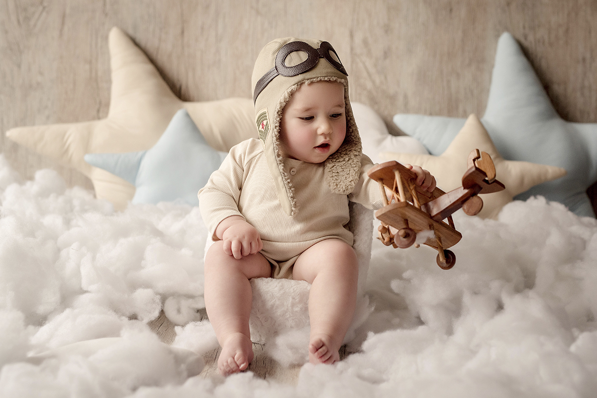 foto de criança em caxias do sul fotografa morgana perini bebe com aviao de madeira na mao