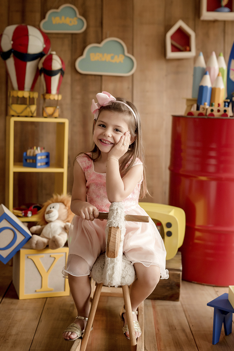 foto de criança em caxias do sul fotografa morgana perini sentada em cavalinho