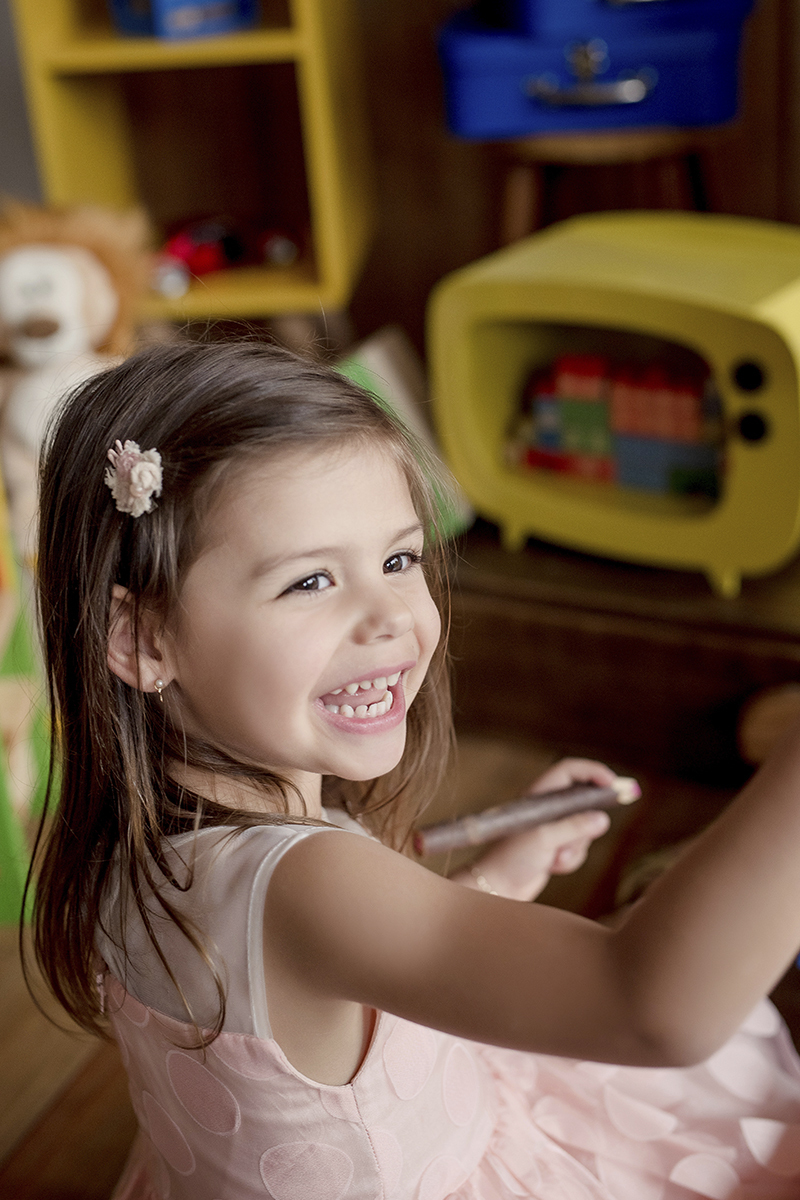 foto de criança em caxias do sul fotografa morgana perini sorrindo com lápis na mão