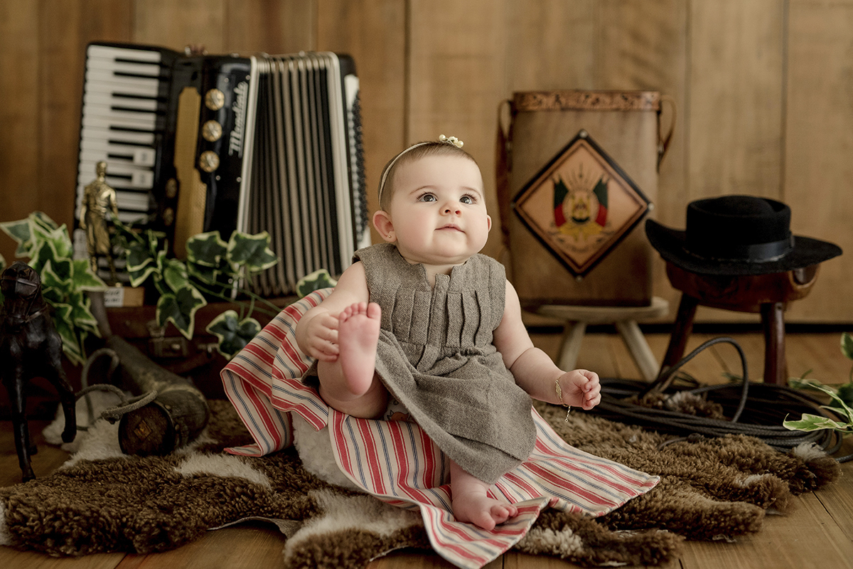 foto de bebe em caxias do sul fotografa morgana perini menina com roupa cinza cenario gaucho