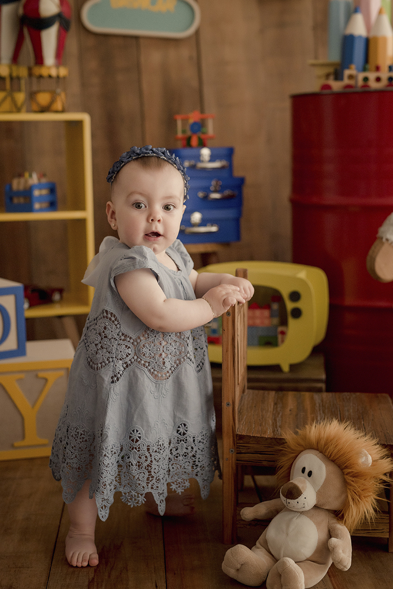 foto de bebe em caxias do sul fotografa morgana perini segurando na cadeira
