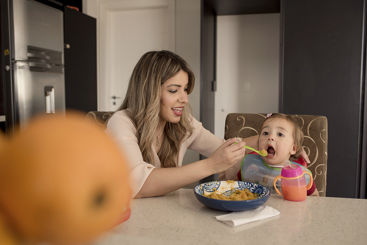 Foto de familia em caxias do sul fotografa morgana perini mae dando comida para filha