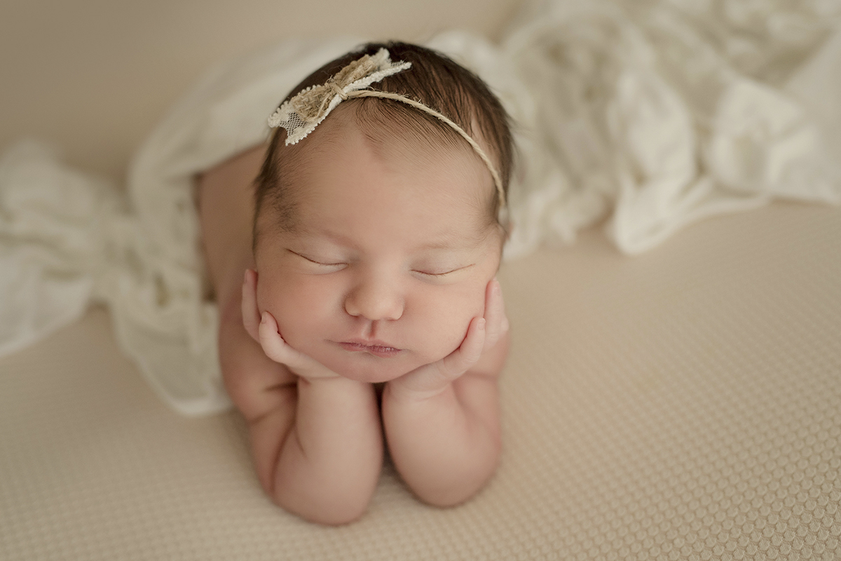 Foto newborn em caxias do sul fotografa morgana perini menina segurando rosto