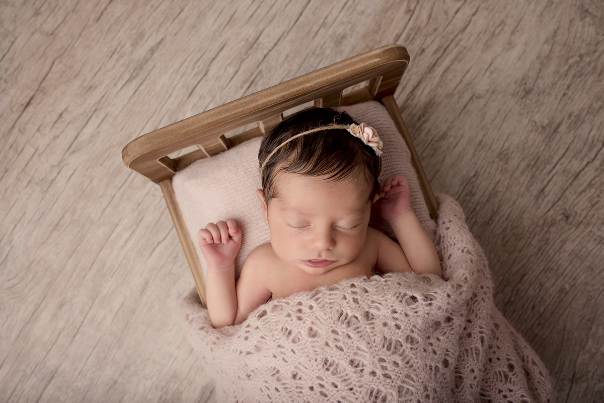 Foto newborn em caxias do sul fotografa morgana perini bebe deitado em cama tons de roxo
