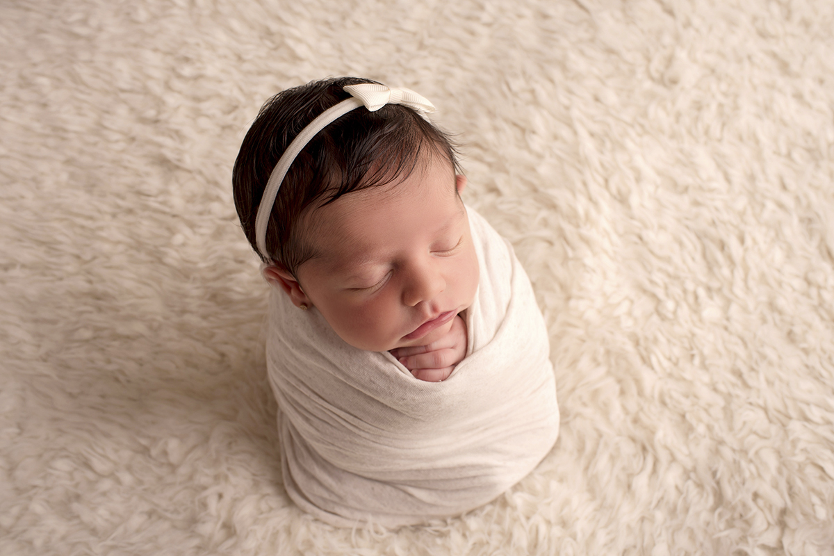 Foto newborn em caxias do sul fotografa morgana perini bebe enroladinha tecido branco tiara