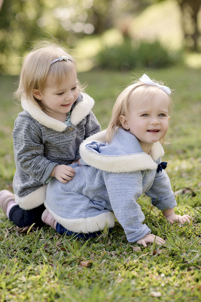 Foto criança em caxias do sul fotografa morgana perini meninas loiras olhos azuis brincando na grama