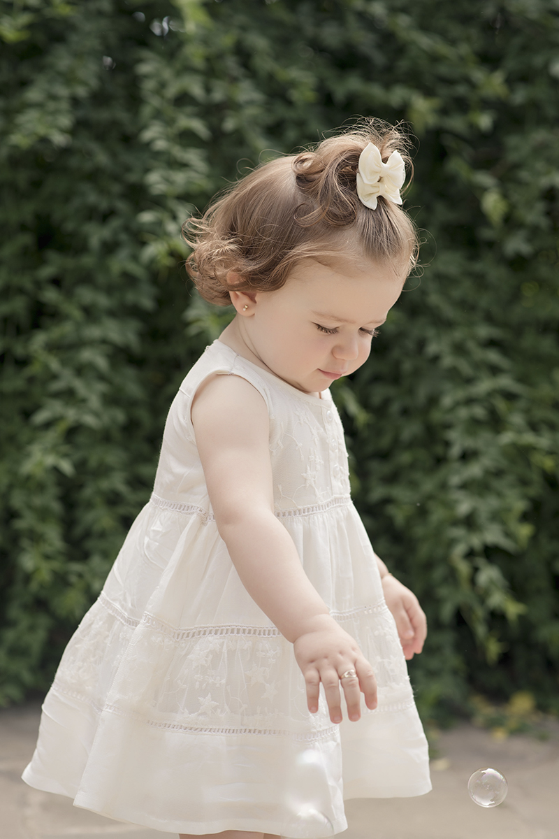 Foto de bebe em caxias do sul fotografa morgana perini menina brincando verde vestido branco