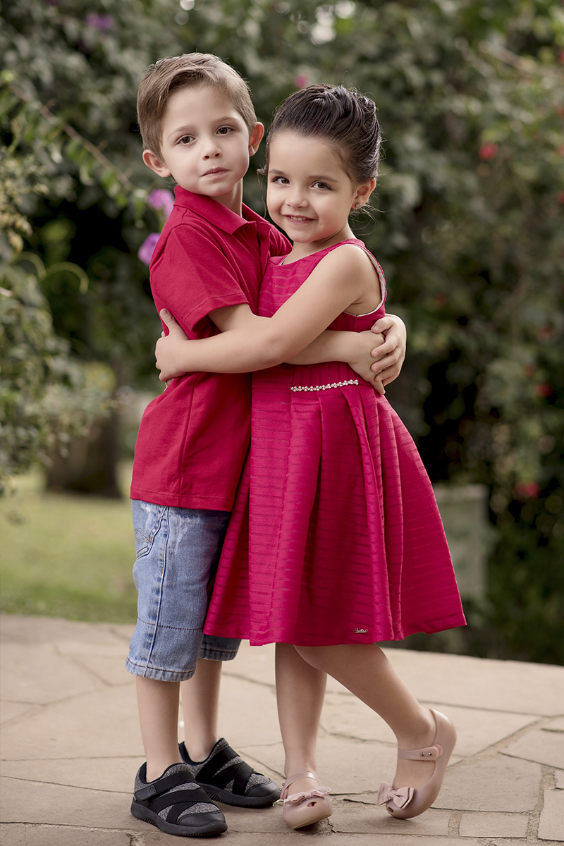 Foto criança em caxias do sul fotografa morgana perini irmaos gemeos abraçados vermelho
