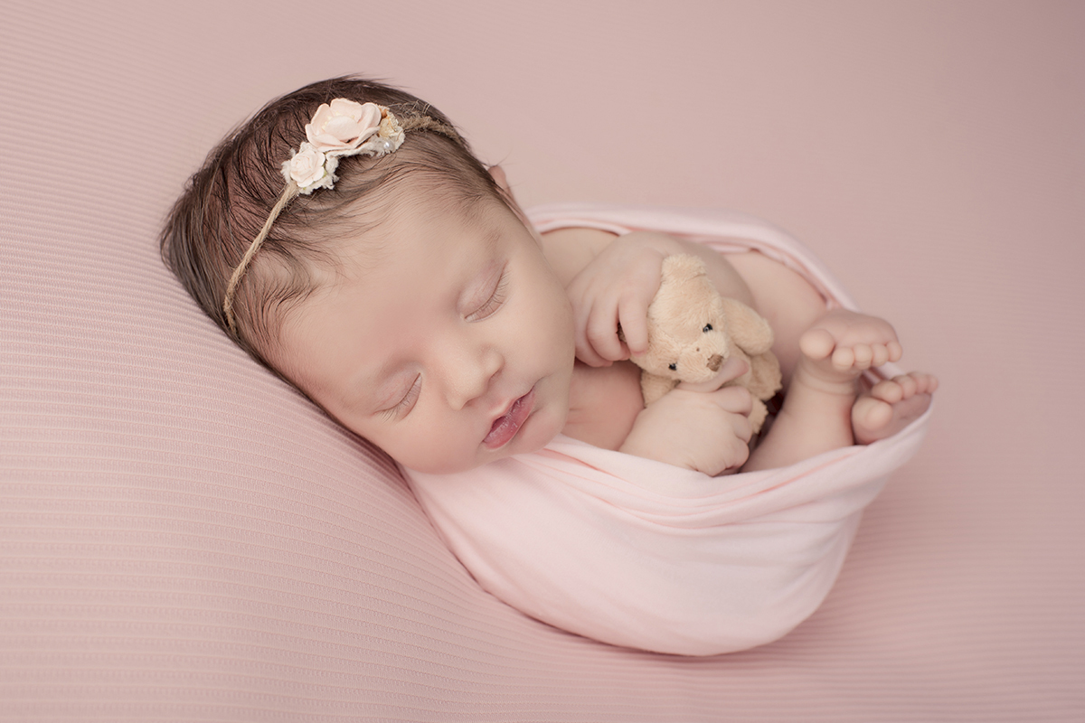 Foto newborn em caxias do sul fotografa morgana perini bebe enrolada rosa urso creme