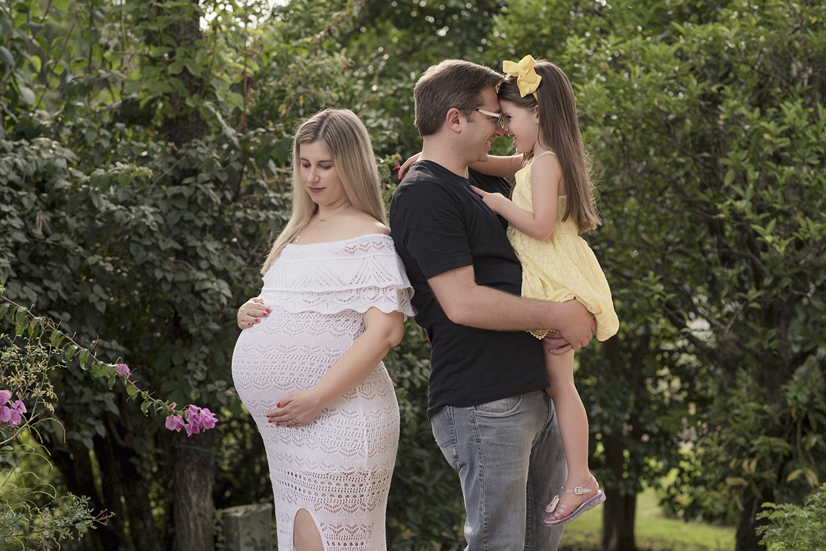 Foto de gestante em caxias do sul fotografa morgana perini gestante olhando barriga vestido branco pai e criança