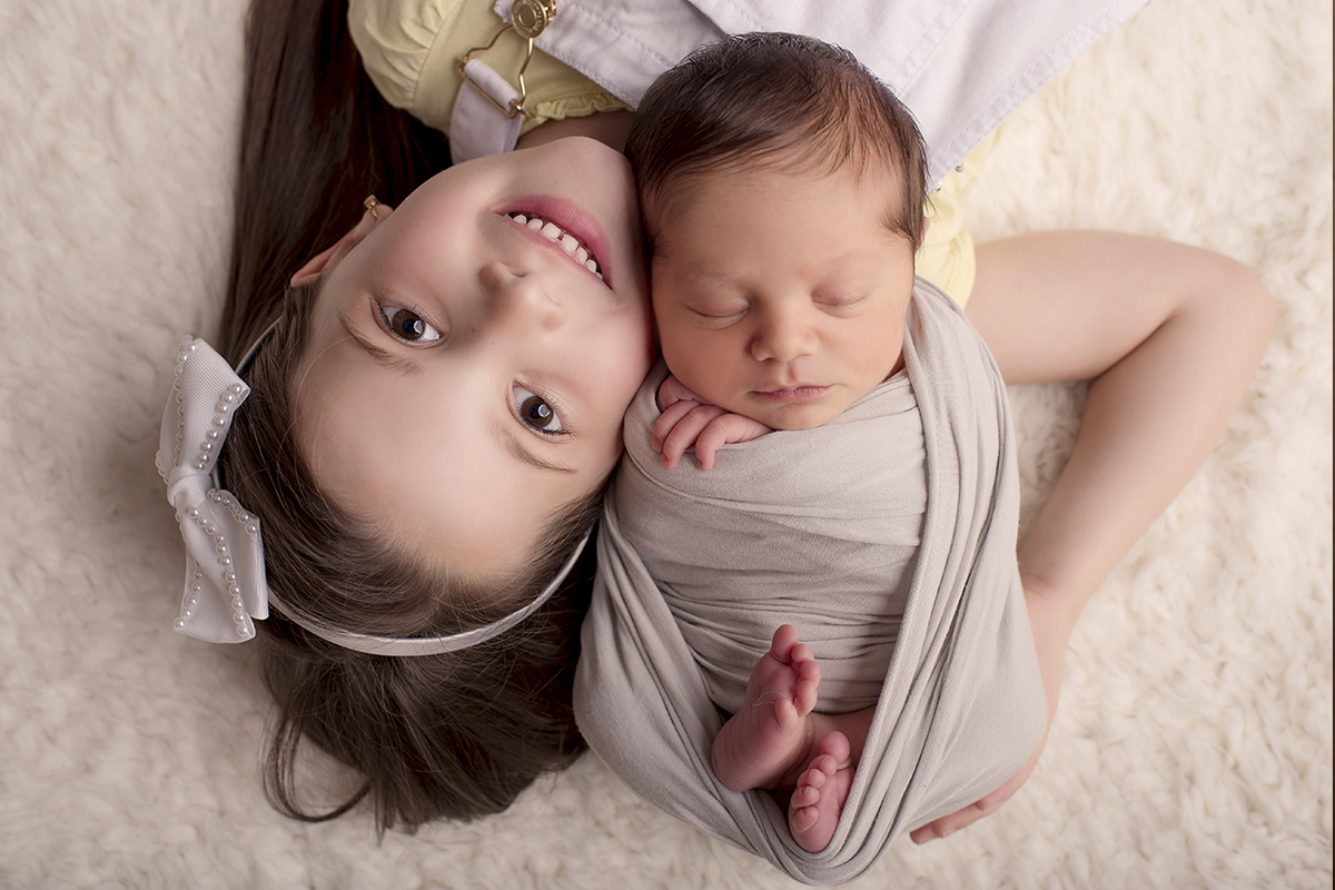 Foto newborn em caxias do sul fotografa morgana perini irma deitada chão bebe