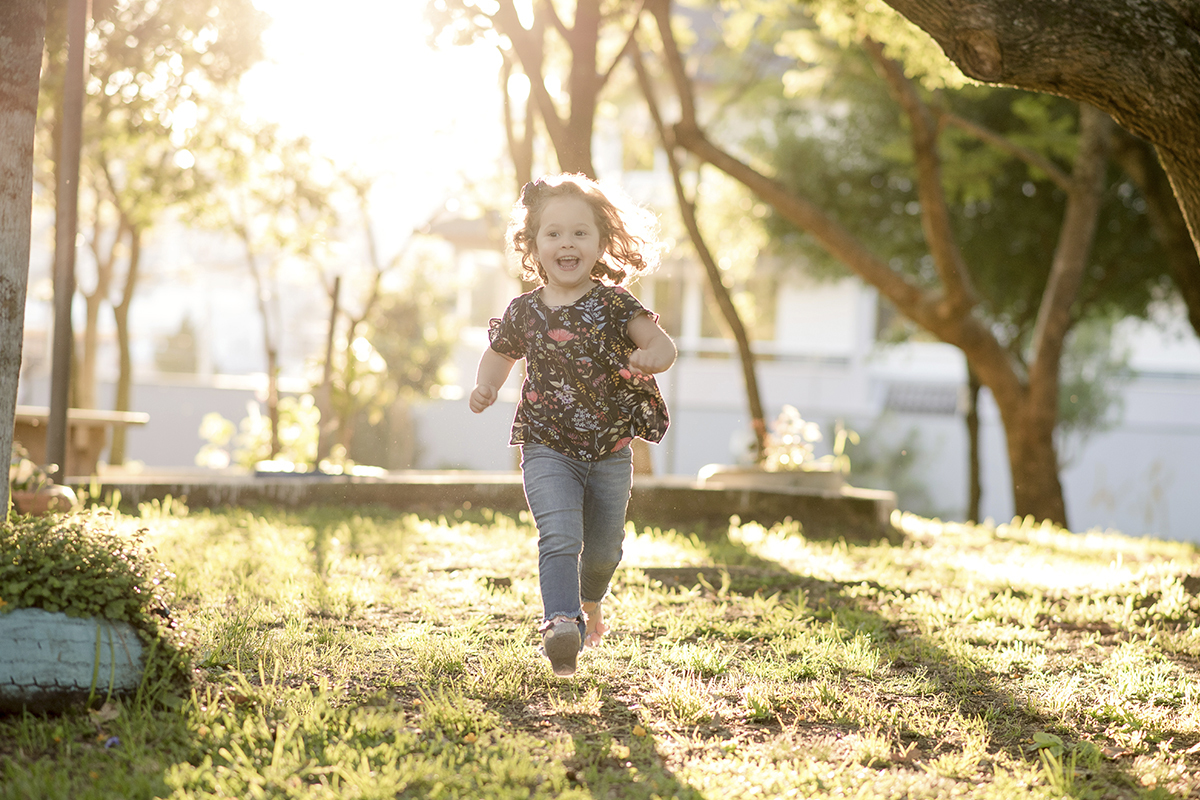 Foto criança em caxias do sul fotografa morgana perini menina correndo blusa calsa jeans