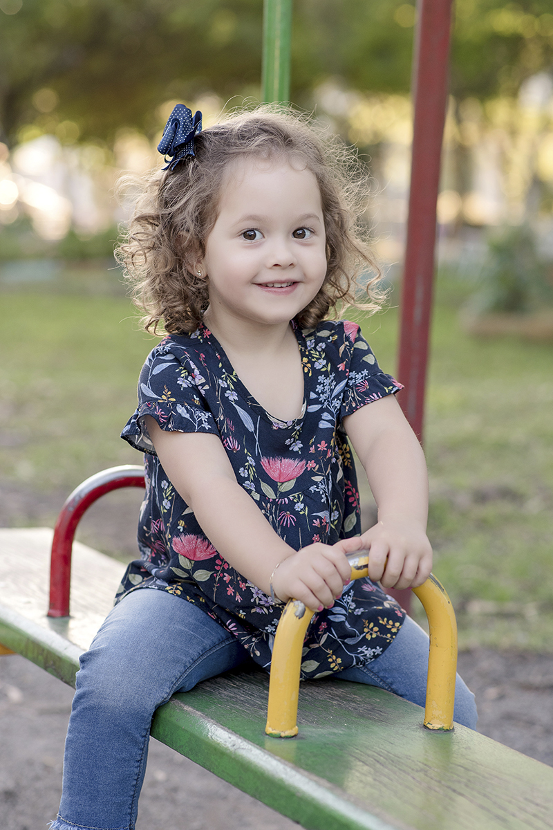 Foto criança em caxias do sul fotografa morgana perini menina em brinquedo vermelho