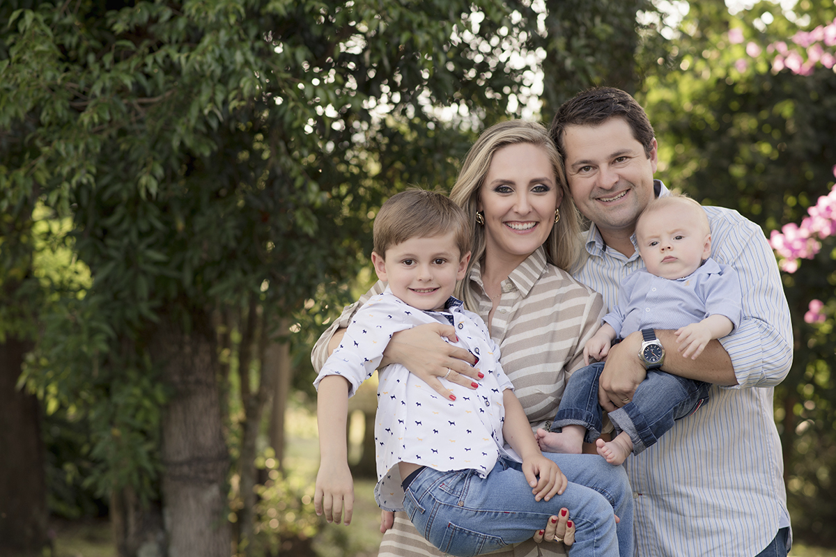 Foto de familia em caxias do sul fotografa morgana perini pais com filhos no colo arvores