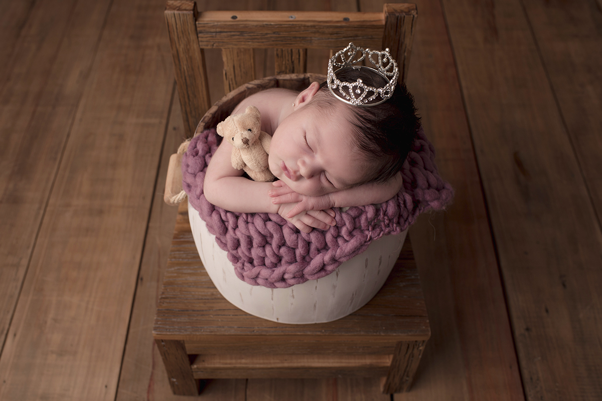 Foto newborn em caxias do sul fotografa morgana perini bebe com mantilha roxa coroa