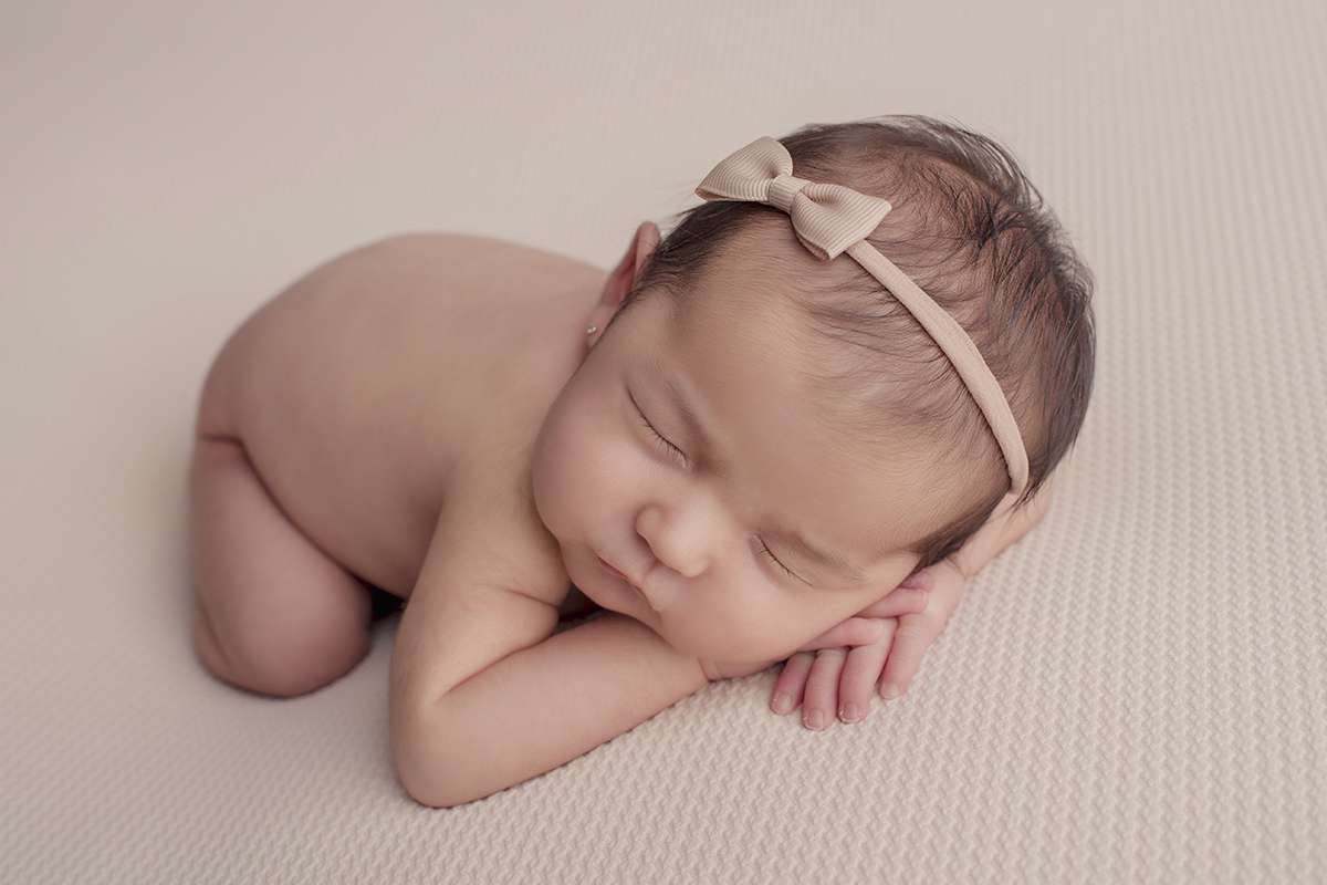 Foto newborn em caxias do sul fotografa morgana perini bebe deitada de bruços tiara