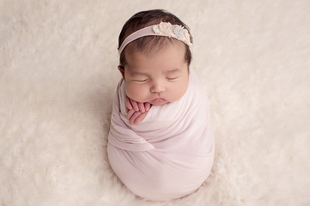 Foto newborn em caxias do sul fotografa morgana perini bebe enrolada tecido rosa claro