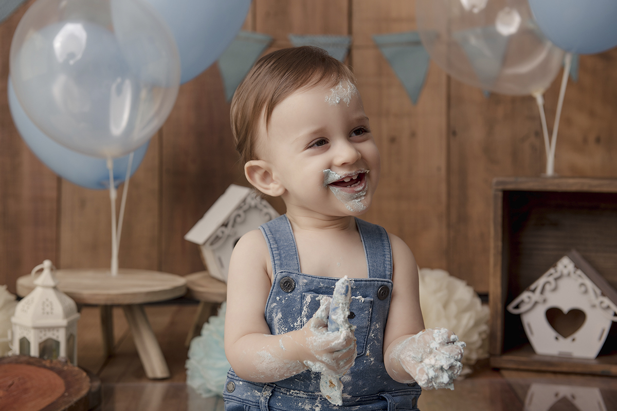 Foto de bebe em caxias do sul fotografa morgana perini bebe sorrindo com bolo nas maos