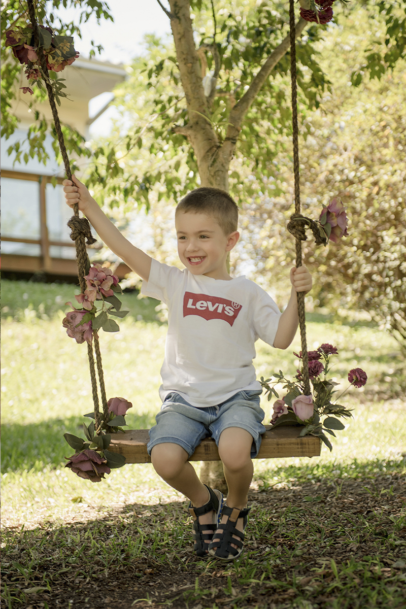 Foto criança em caxias do sul fotografa morgana perini criança em balanco sorrindo