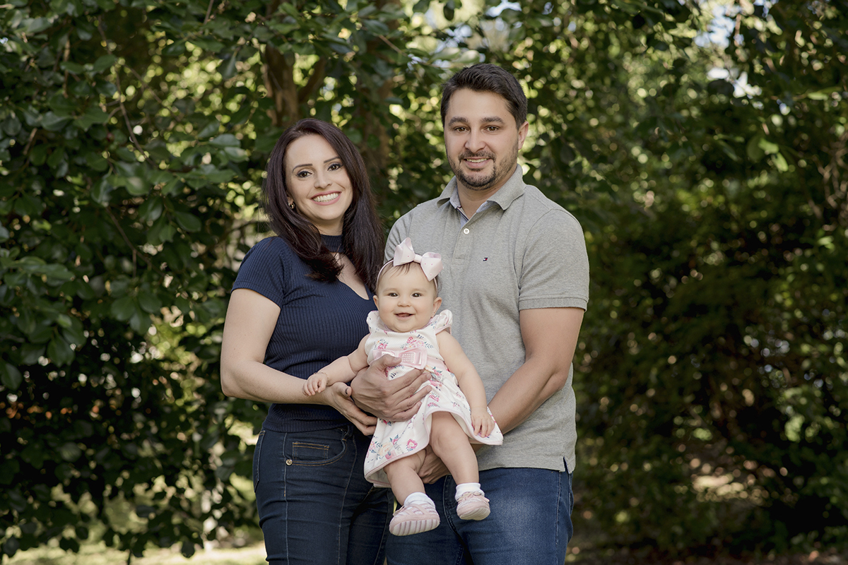 Foto de bebe em caxias do sul fotografa morgana perini pais com menina em jardim sorrindo