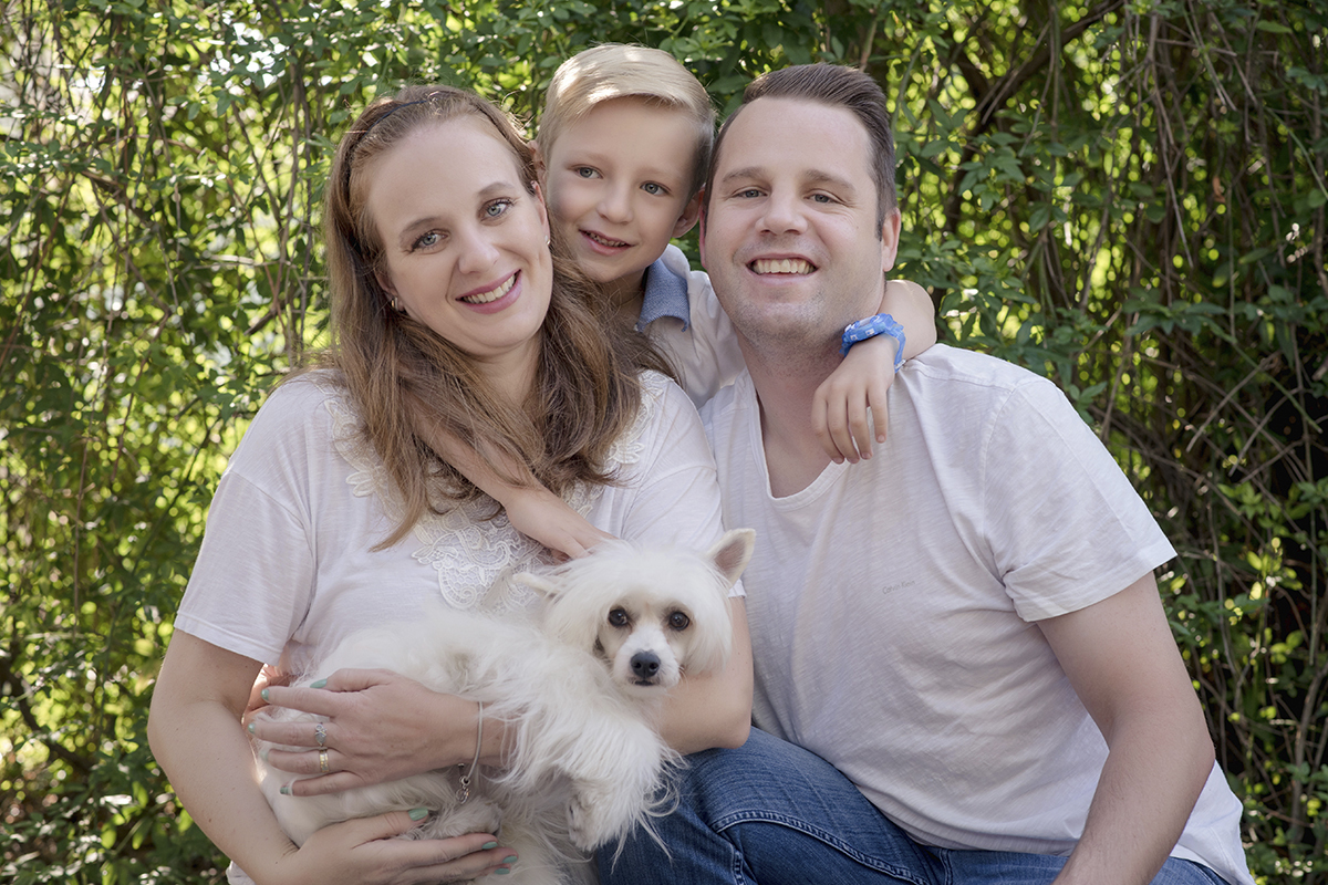 Foto de familia em caxias do sul fotografa morgana perini pais e filho com cachorro branco verde