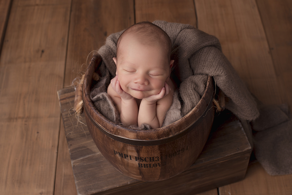 Foto newborn em caxias do sul fotografa morgana perini bebe segurando rostinho sorrindo