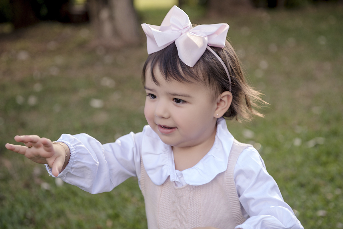 Foto criança em caxias do sul fotografa morgana perini menina laço rosa jardim