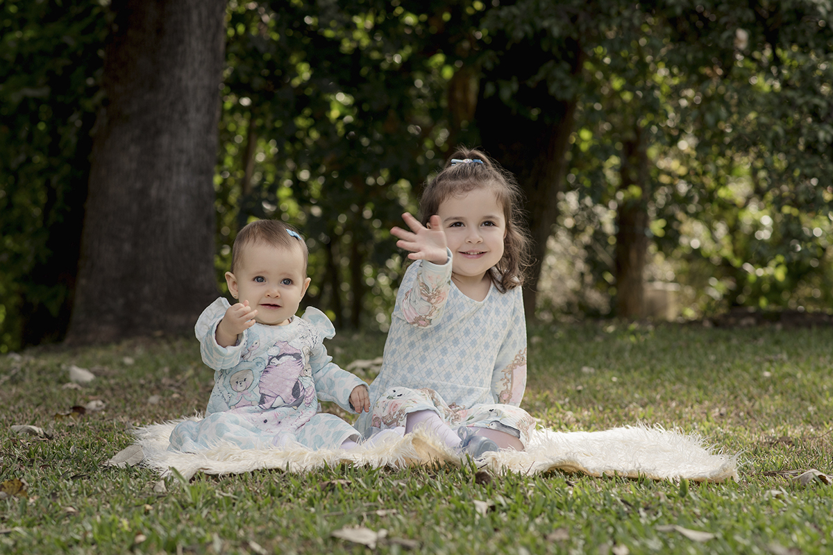 Foto criança em caxias do sul fotografa morgana perini irmas sentadas na grama