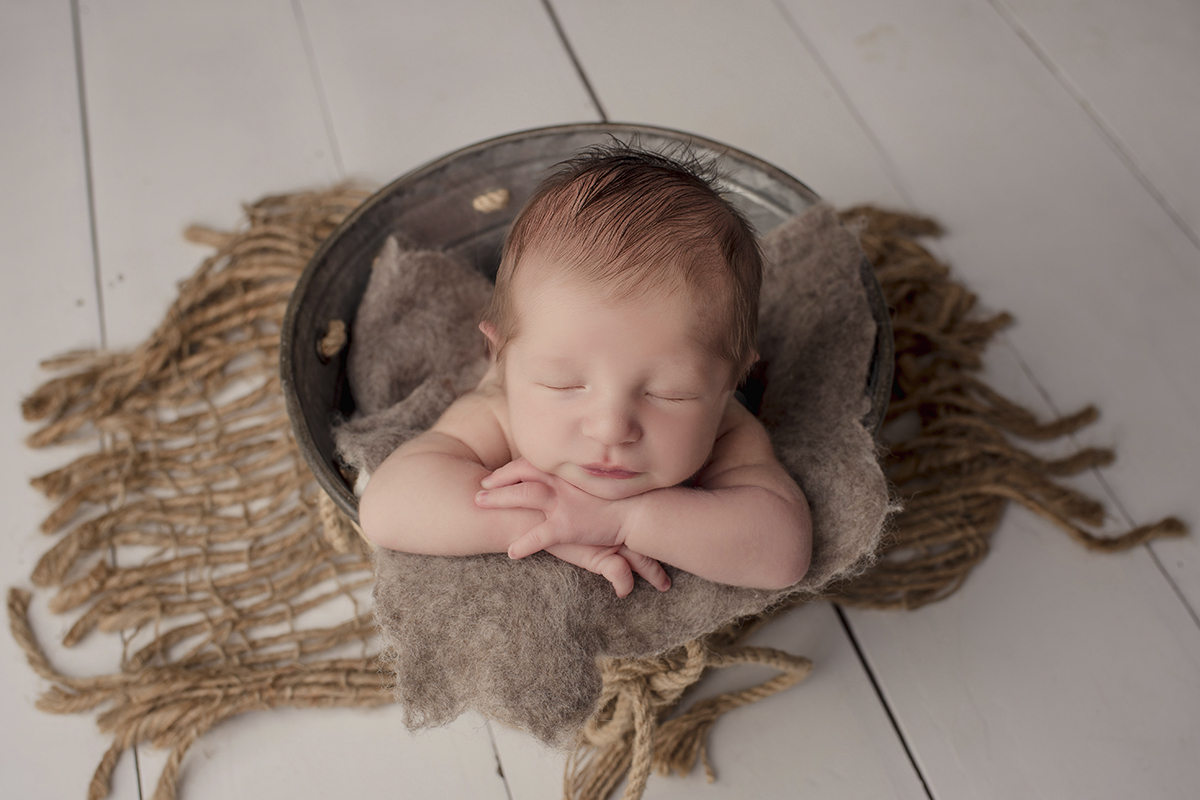 Foto newborn em caxias do sul fotografa morgana perini bebe de bruso sobre os braços
