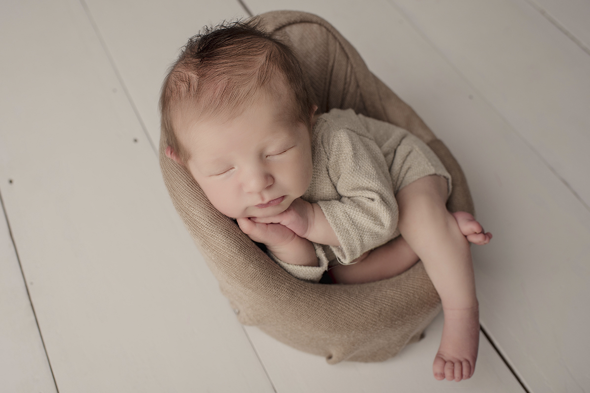 Foto newborn em caxias do sul fotografa morgana perini bebe sentado de lado maos juntas