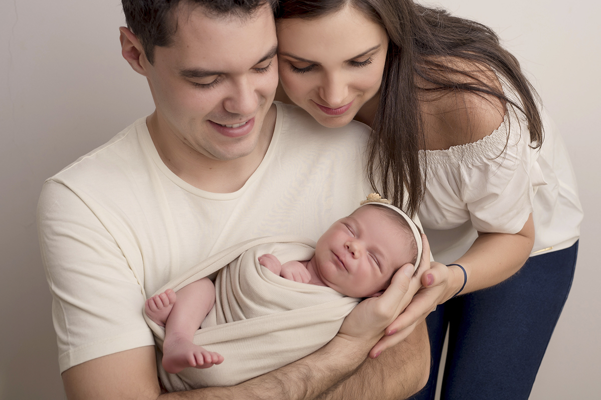 Foto newborn em caxias do sul fotografa morgana perini no colo do pai mae abraçando
