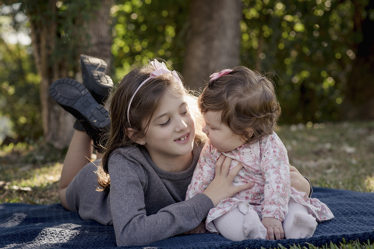 Foto de bebe em caxias do sul fotografa morgana perini irmas se olhando deitadas na grama