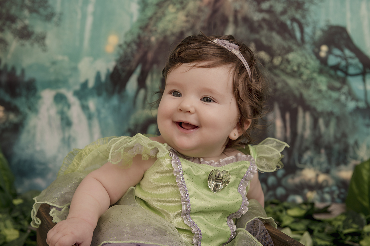 Foto de bebe em caxias do sul fotografa morgana perini bebe sorrindo vestido verde floresta