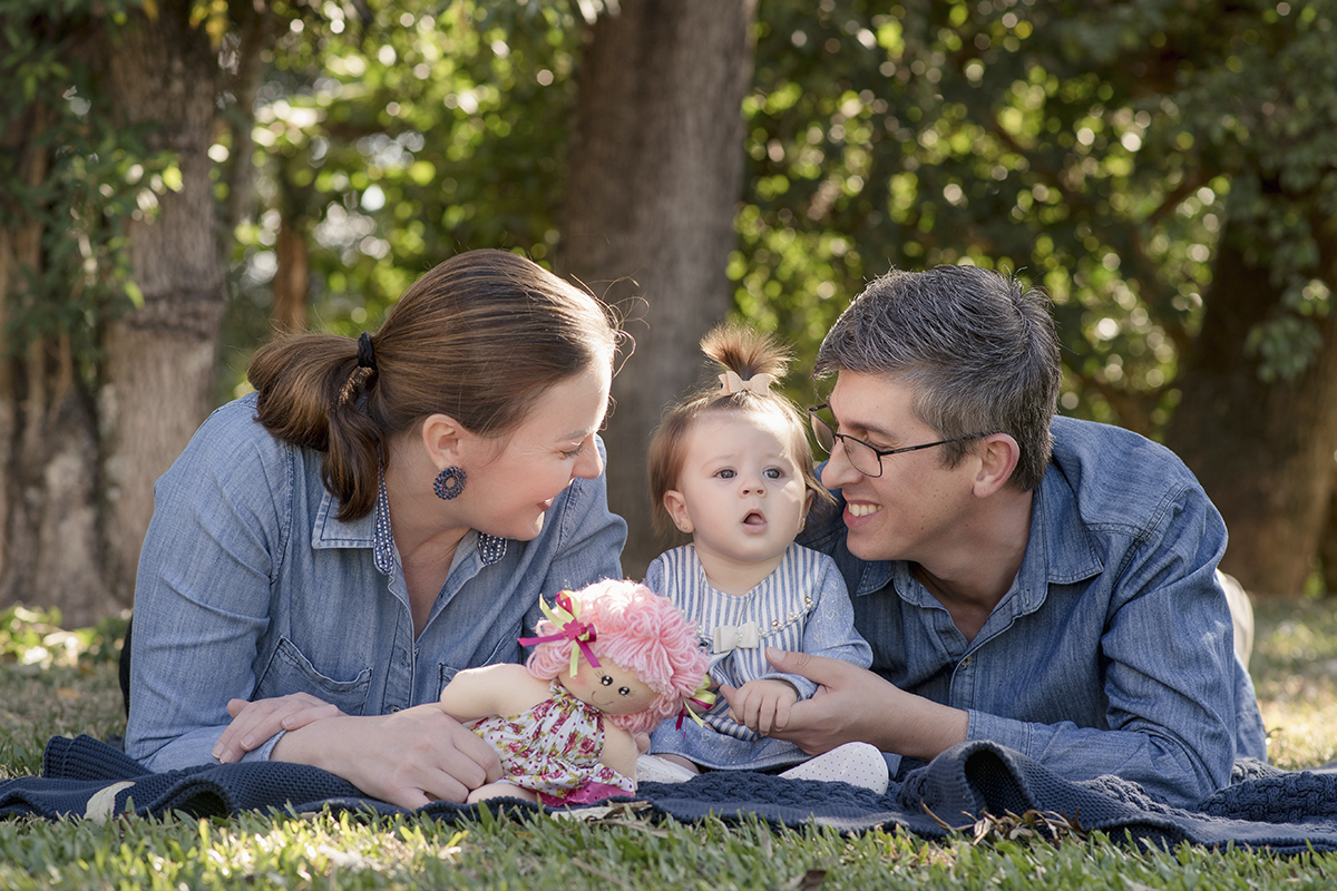 Foto de bebe em caxias do sul fotografa morgana perini pais com filha deitados na grama