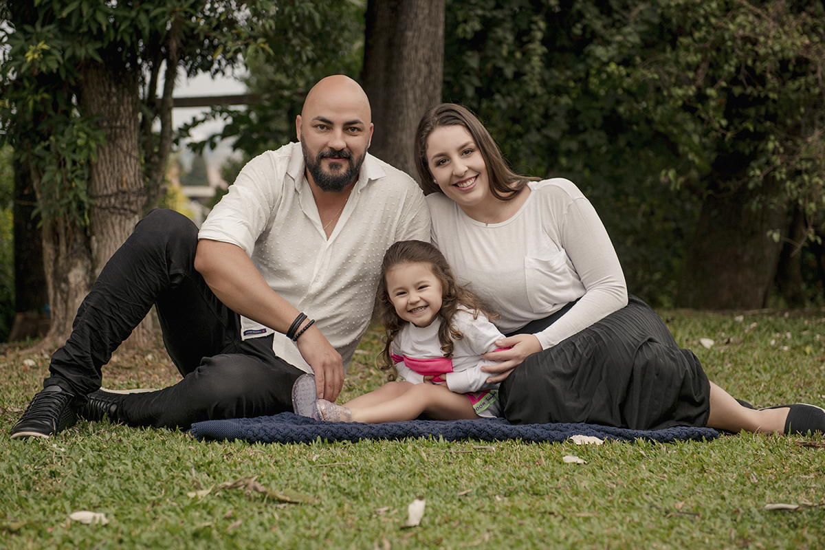 Foto de bebe em caxias do sul fotografa morgana perini com pais sentados na grama