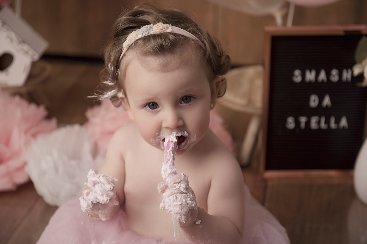Foto de bebe em caxias do sul fotografa morgana perini comendo bolo rosa